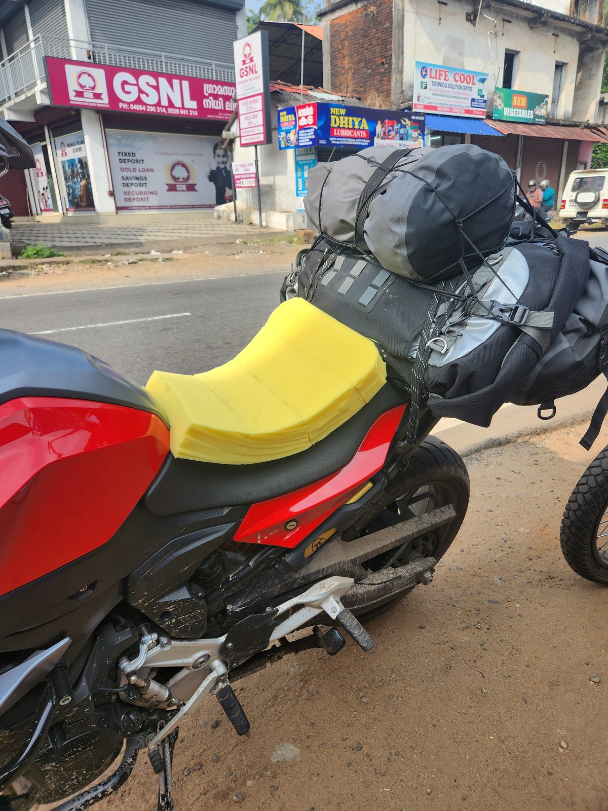 A bright yellow piece of foam laid on top of the motorcycle seat as a temporary cushion
