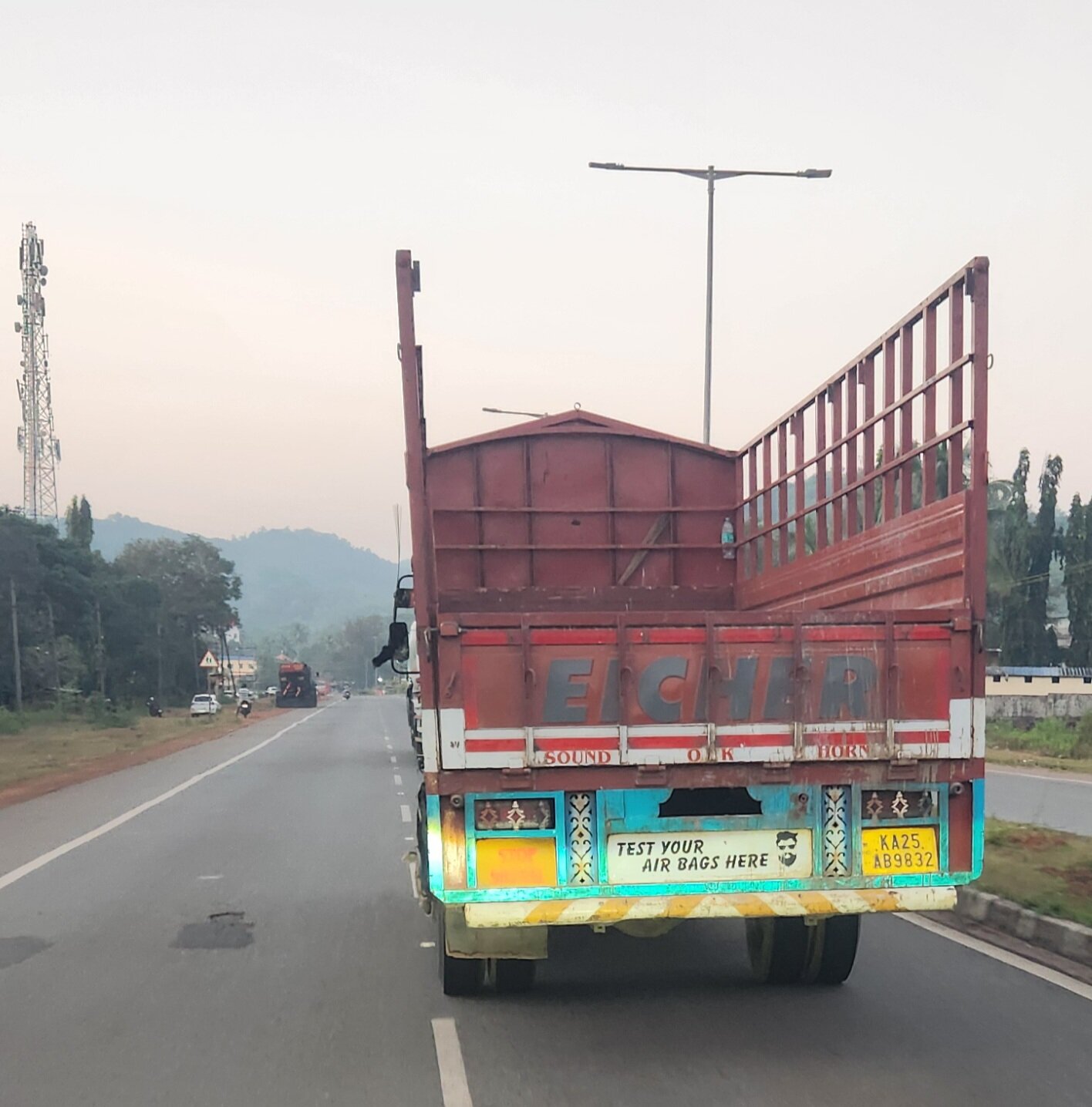 An Eicher truck on the highway with the words TEST YOUR AIR BAGS HERE painted on the back