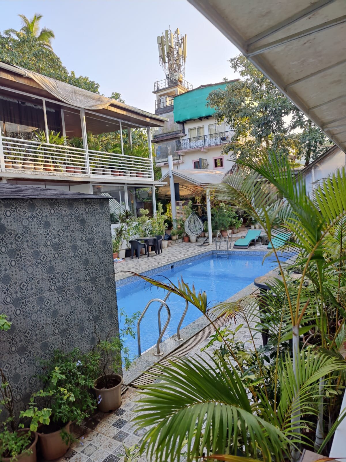 The inner courtyard pool at White Flower Cottages with palms and tiled walkways