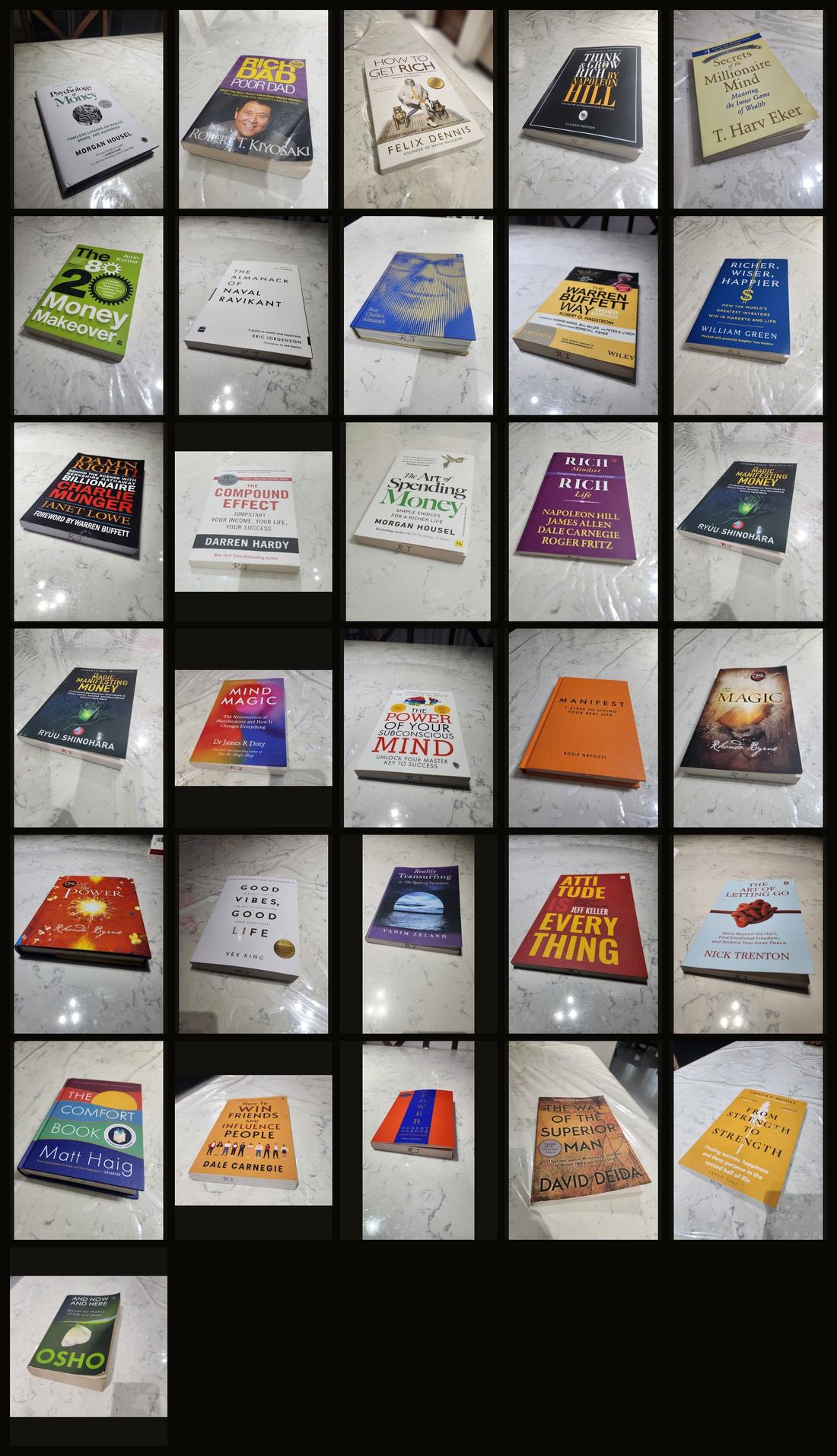 All thirty-one books I've read so far — money, mindset, habits, manifestation and life — photographed on the kitchen counter